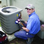 HVAC technician inspects air conditioner.